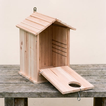 The drop-front hatch swung open showing the deep interior cavity and rough-sawn climb-out wall