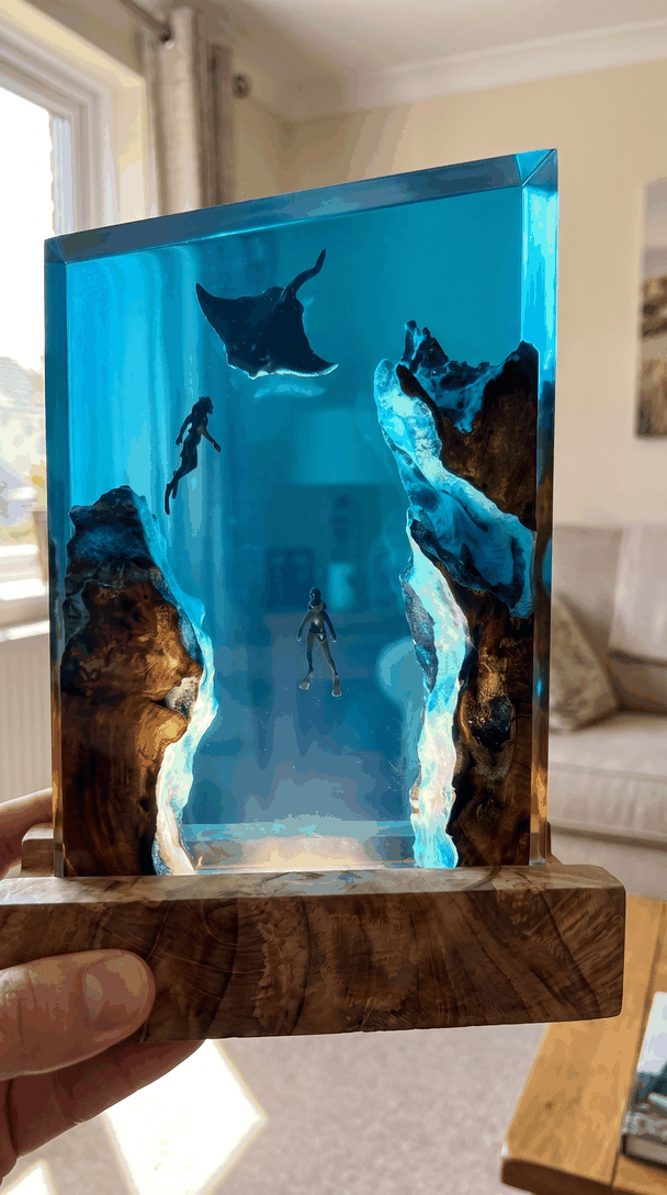 Close-up of the manta lamp held in hand showing the layered depth