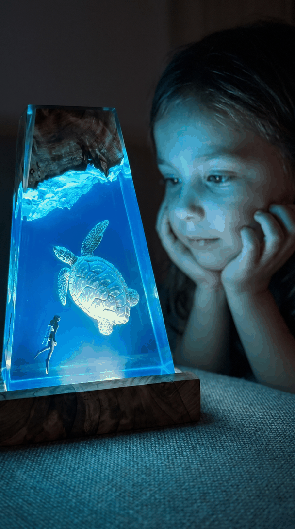 A child's face lit by the blue glow of the turtle lamp