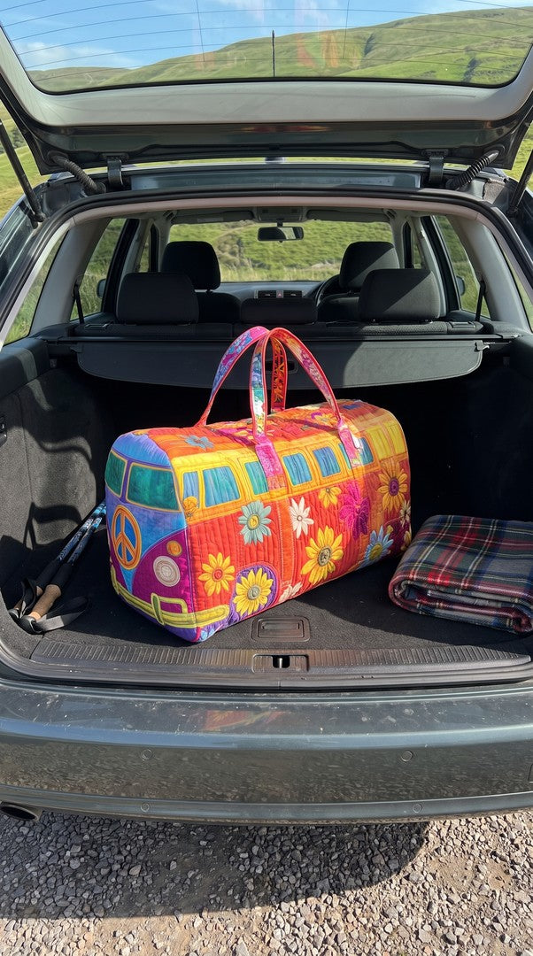 The weekender in the boot of a car with hills behind