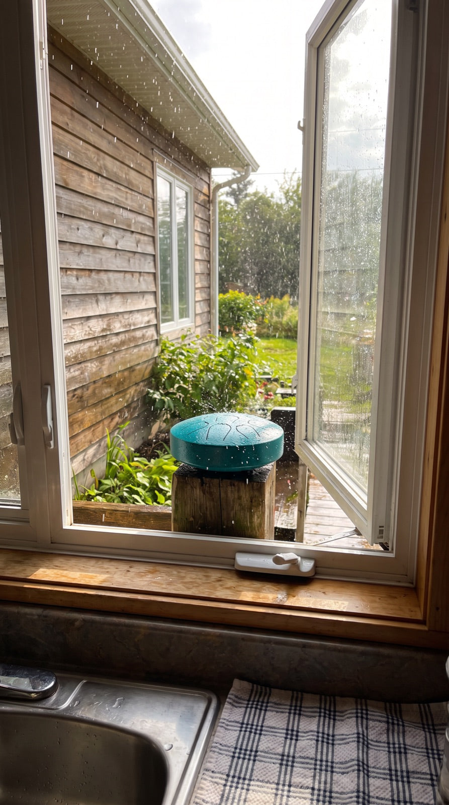Rain drum on a post outside an open kitchen window