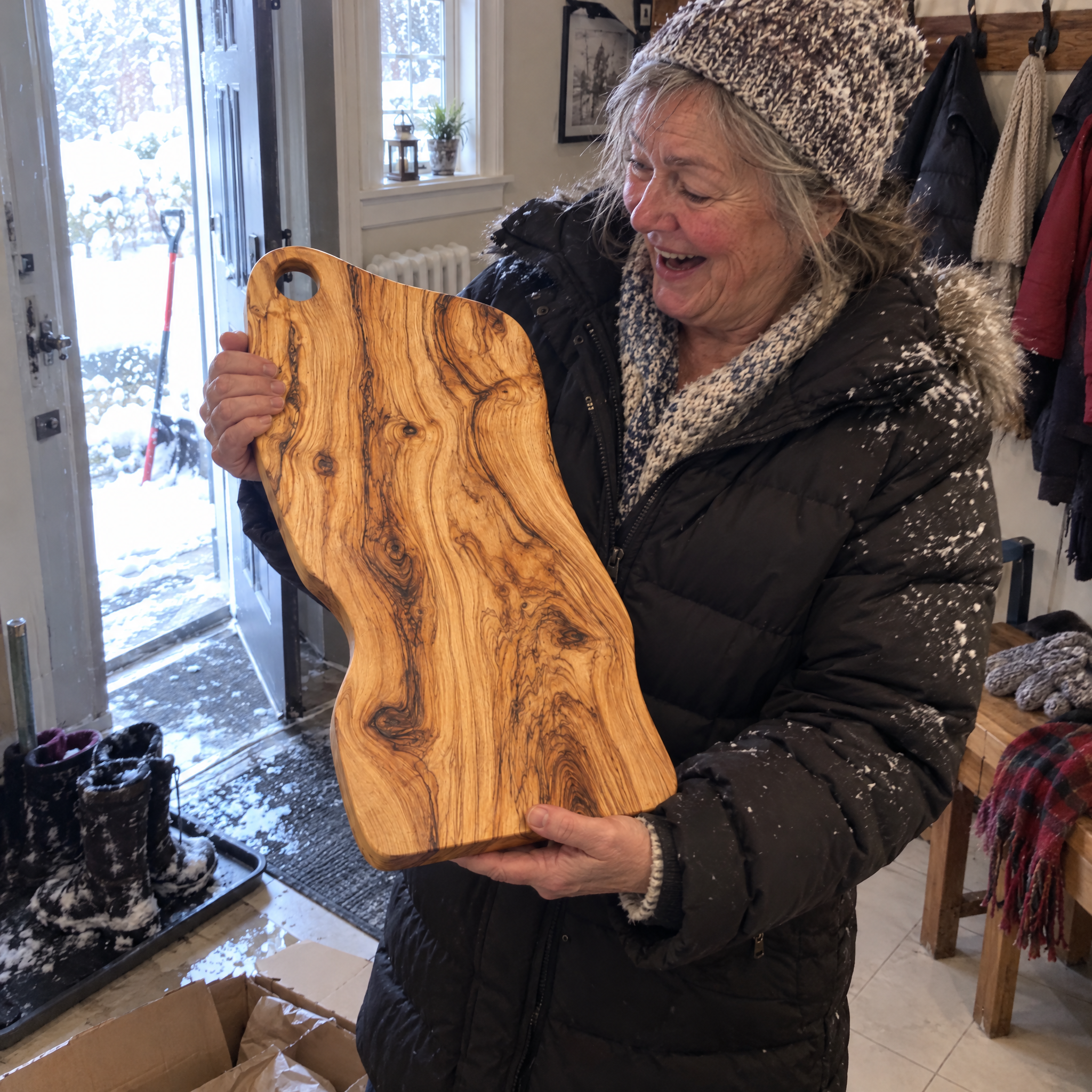 Customer unboxing the olive wood board in her front hall in winter