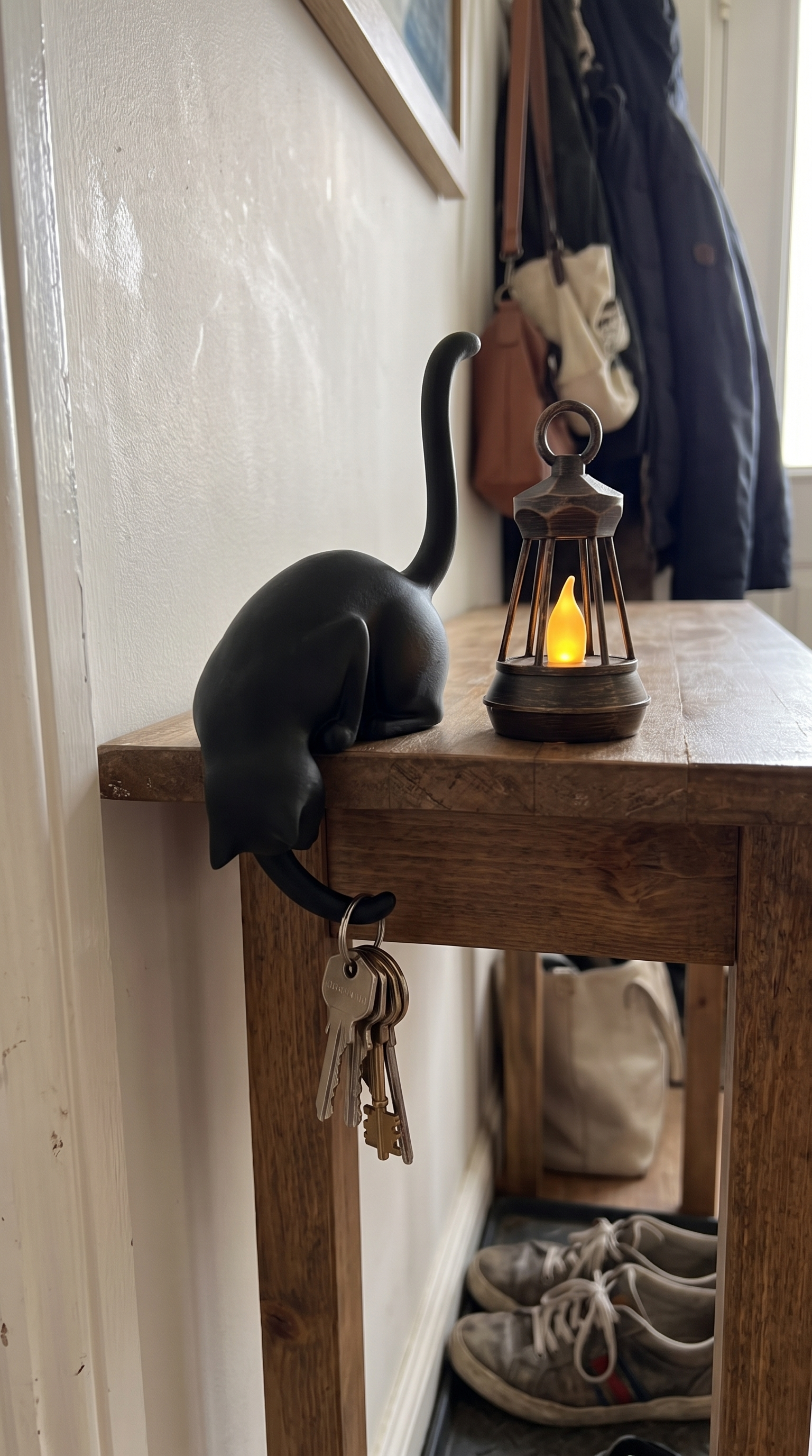 Owner photo: ink black cat lantern in a hallway with keys on the paw