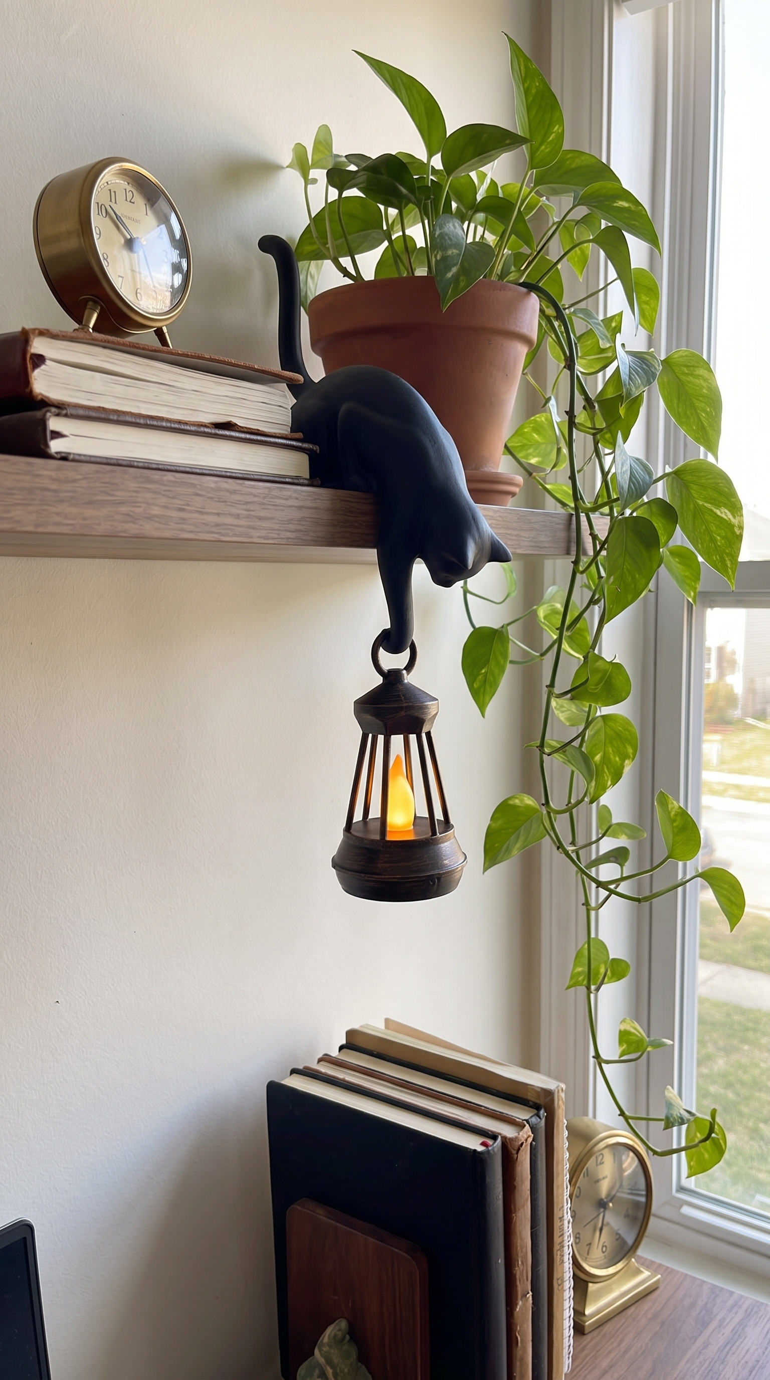 Owner photo: ink black cat lantern on a home office shelf