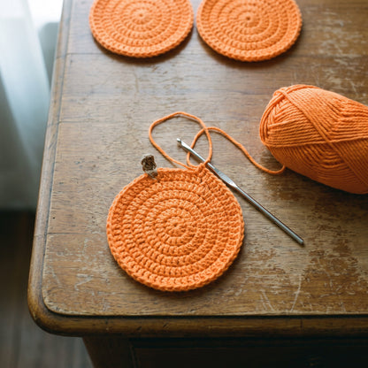 Coaster being crocheted by hand