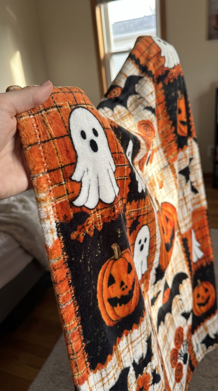 Hand holding up the blanket edge showing the stitched hem
