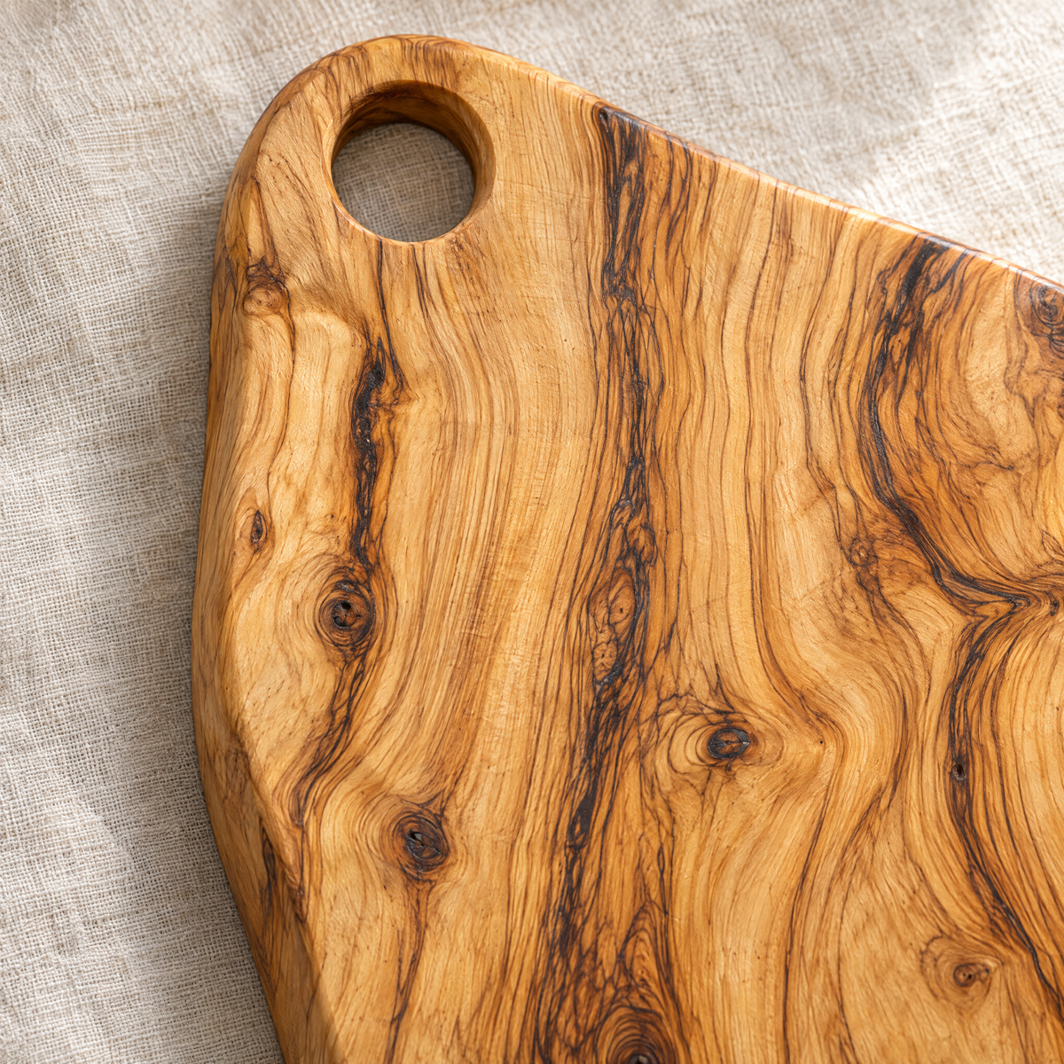 Close-up of the olive wood grain and handle hole of Sandro's board