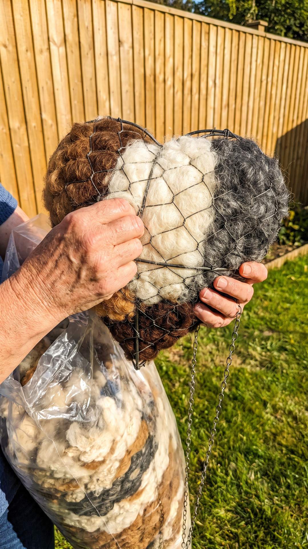 Hands refilling the nesting heart with fresh fleece