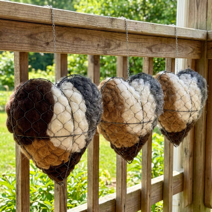 Three alpaca nesting hearts hanging from a verandah rail