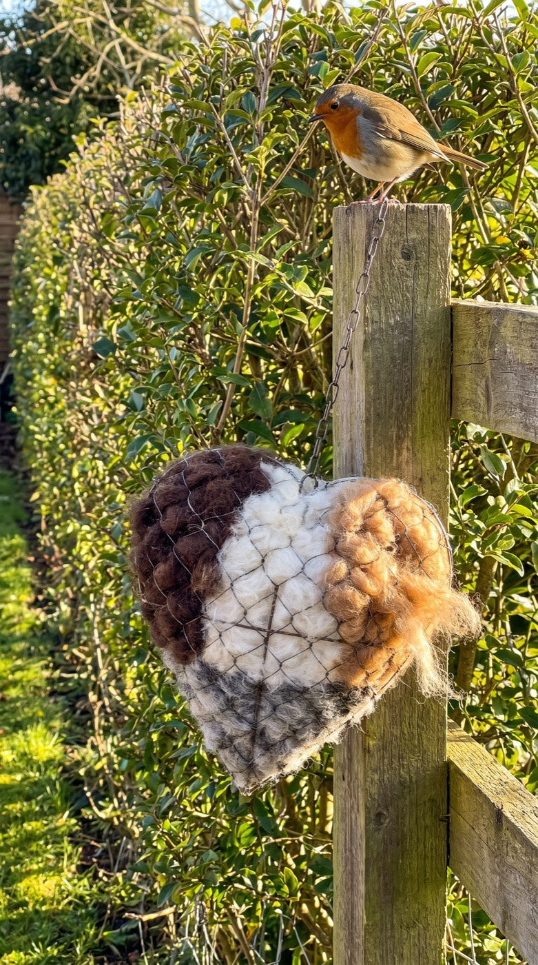 A robin above the nesting heart on a garden fence post
