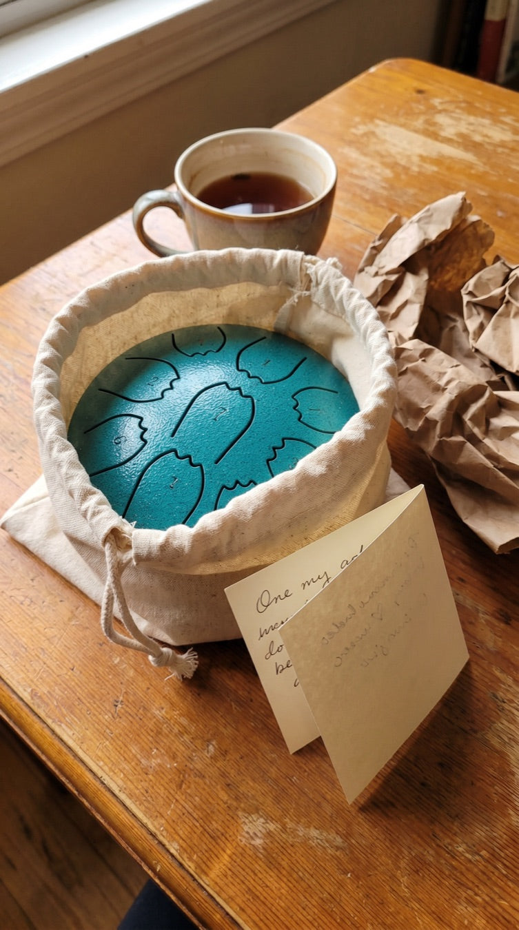 Rain drum with its cloth pouch and handwritten note